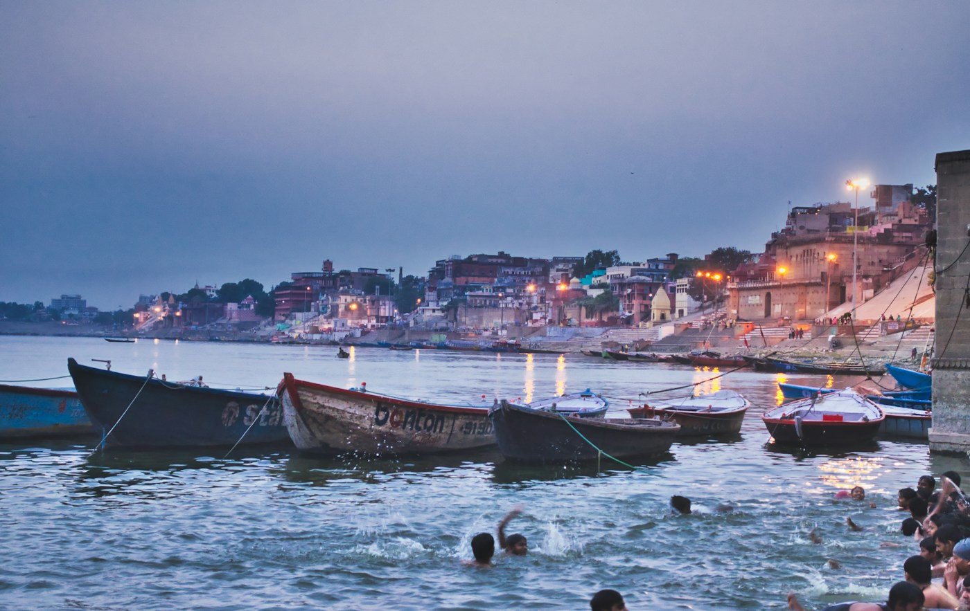 Golden dawn sunlight illuminating the ancient river steps and boats in Varanasi